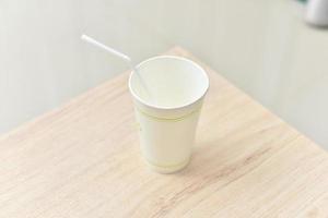 a paper cup on a wooden table photo