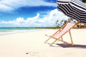 Relax on tropical beach in the sun on deck chairs. photo