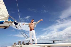 Young man sailing his boat on the open ocean photo