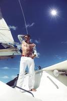 Young man sailing his boat on the open ocean photo