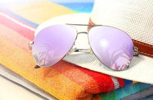 Summer tropical beach background with sunglasses and hat. photo