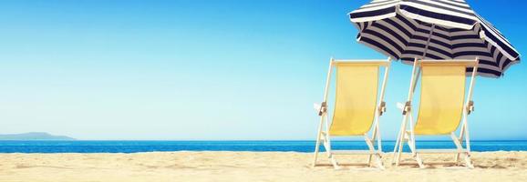 Relax on tropical beach in the sun on deck chairs. photo