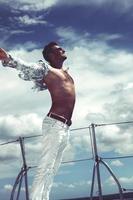 Young man sailing his boat on the open ocean photo