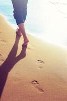 Walking on the beach, leaving footprints in the sand. photo