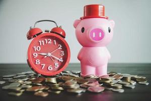 Pink piggy bank on table with coins photo