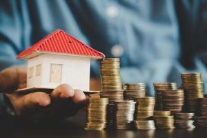 Coins stacking with house model photo