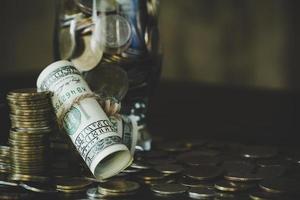 dollars with coins in jug glass photo