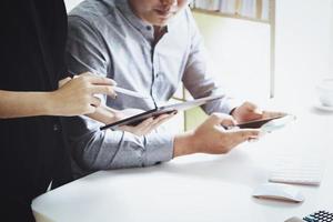An investment expert using pen points at a computer monitor to analyze the stock market to teach you how to make a profit. photo