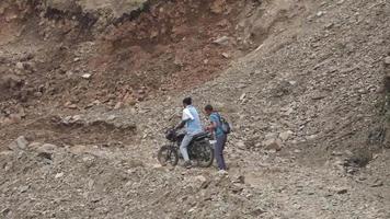 26 février 2022 uttarakahnd, inde. un motard à deux roues s'est fait prendre dans un glissement de terrain dans l'uttarakhand. essayant de pousser leur moto au milieu des rochers. video