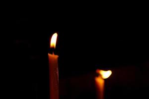 Golden candle light in worship on Buddhist holy day photo