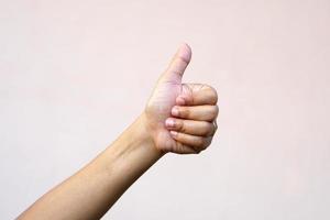 Asian woman's hand raising thumbs as a sign of greatness photo