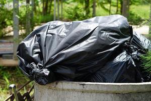black bag overflowed from the garbage collector. photo
