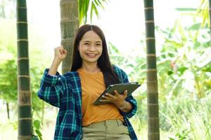 female farmer is happy after viewing results from a laptop computer. Increased profits photo