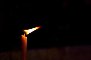 Golden candle light in worship on Buddhist holy day photo