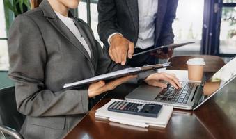 Business documents on office desk with tablet, graph and two colleagues discussing data working photo