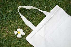 fabric bag on green grass background with flower photo