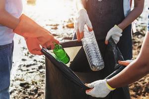 mujer voluntaria recogiendo plástico de basura para limpiar en el parque fluvial foto