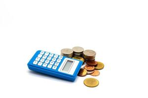 monedas y calculadora azul sobre fondo blanco foto