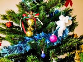 Holiday in vintage color concept, gold ball hanging on the branch of Christmas tree with blue tinsel, golden ball and white angel photo