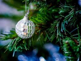 Holiday in blue tone concept, crystal ball hanging on the branch of Christmas tree photo