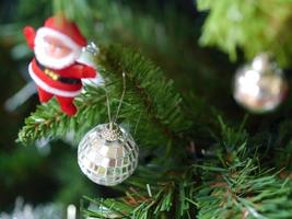 Holiday concept, crystal ball hanging on the branch of Christmas tree with Santa Claus photo