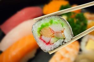 sushi maki in chopsticks photo