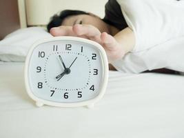 white alarm clock and sleeping woman photo