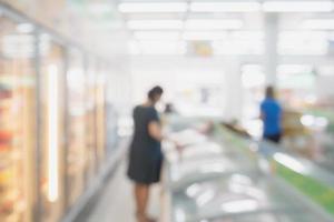 Blur pregnant woman at Frozen food section in supermarket photo