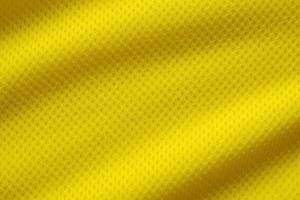 Yellow color football jersey clothing fabric texture sports wear background, close up photo