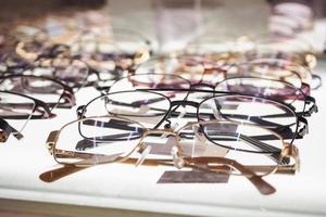 Eye glasses on window display shelves in optics store photo