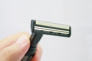 Hand with shaving razor isolated on a white background photo