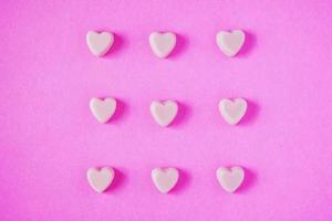 valentine candy hearts shape on pink background photo