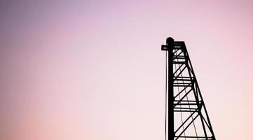 Silhouette pile driver at construction site photo