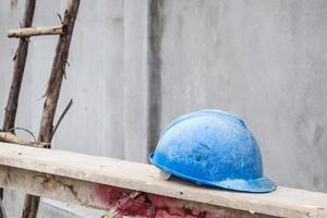 Blue hard hat on house building construction site photo