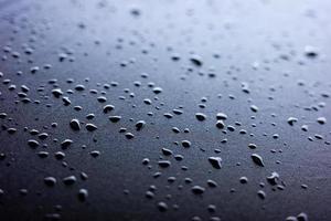 Selective focus on water drops on black synthetic fabric. photo