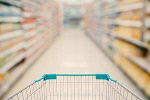 Shopping cart view with Supermarket aisle blurred background photo
