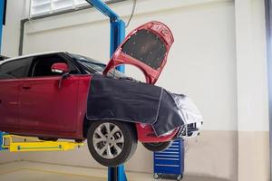 coche rojo en la estación de servicio de reparación de automóviles esperando mantenimiento foto