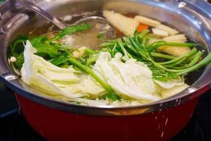 las verduras hierven en una olla sukiyaki foto