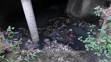 A gutter full of plastic and toxic waste flowing in open.