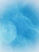 Defocus blurred transparent blue colored clear calm water surface texture with splashes and bubble photo