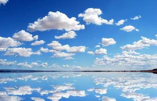 amazing clear blue sky and clouds with mirror reflections of sky and clouds on the lake. photo