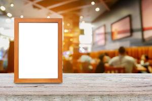 photo frame on wood table over restaurant blur background