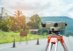 Surveyor equipment tacheometer or theodolite with road construction site background photo