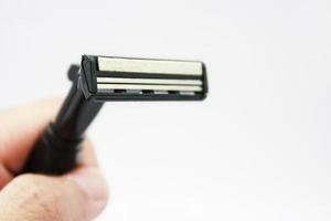 Hand with shaving razor isolated on a white background photo