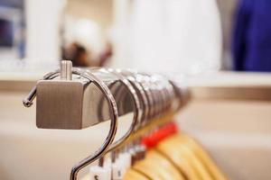 Close up clothes hanging on rack in boutique store photo