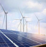 solar panels and wind turbines with the clouds and sky photo