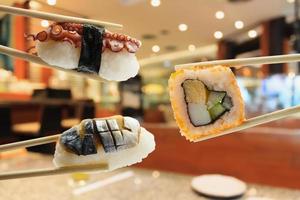 sushi en palillos con interior de restaurante japonés foto