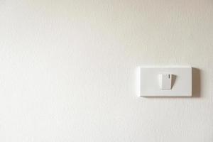 light switch on white concrete wall photo