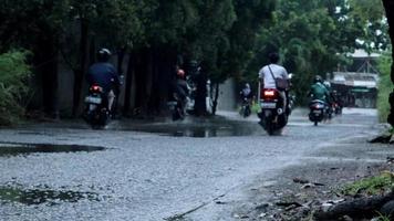 tangerang, 01 maggio 2022 - un veicolo a motore a due ruote attraversa una pozza d'acqua alluvionale. video