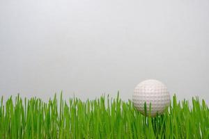 Golf ball on a green lawn on a white background. photo